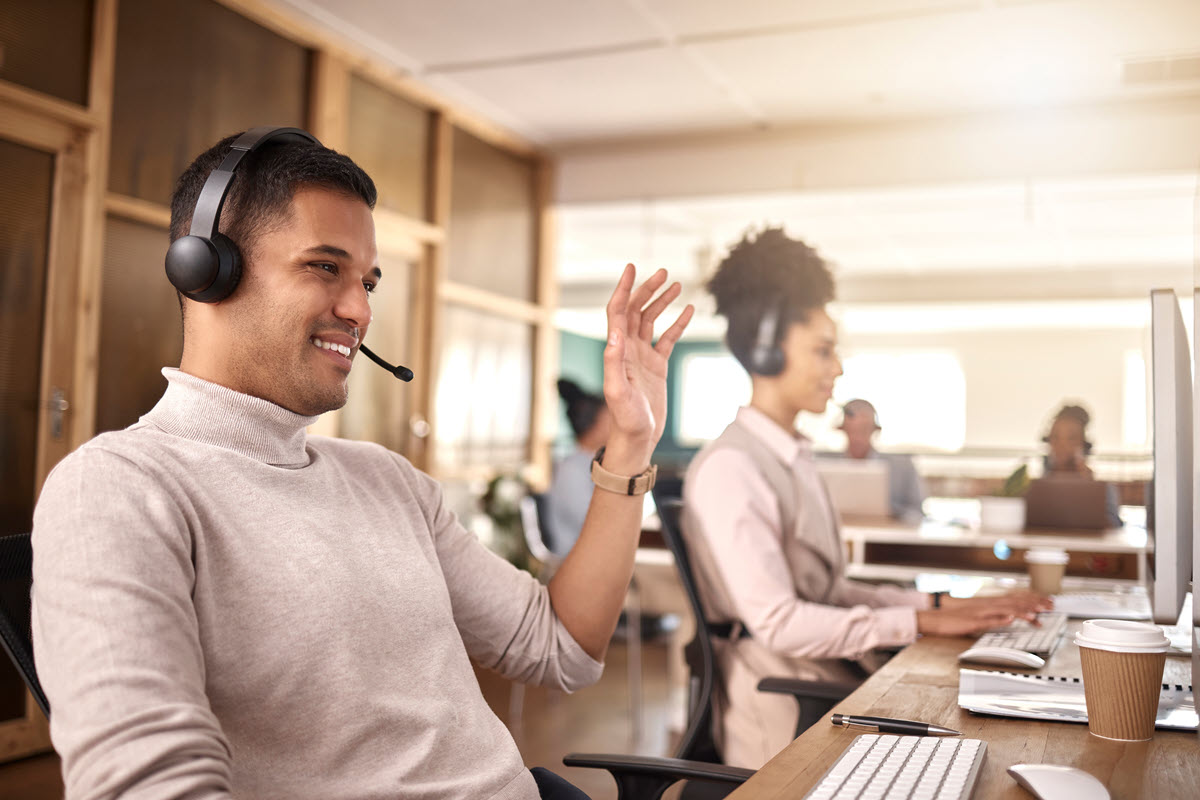 Call center support agent happy on a call after Six Sigma project.